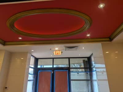 Commercial interior with a red ceiling, white trim details, and glass entry doors.