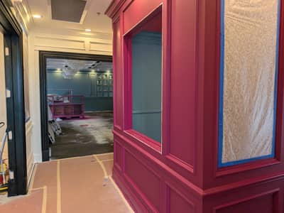 Commercial space with burgundy painted walls, blue trim accents, and clear partition walls.
