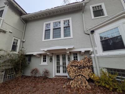 Two-story white house with multiple windows and dark roof.