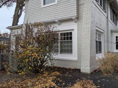 White house section with bay window and multiple panes.