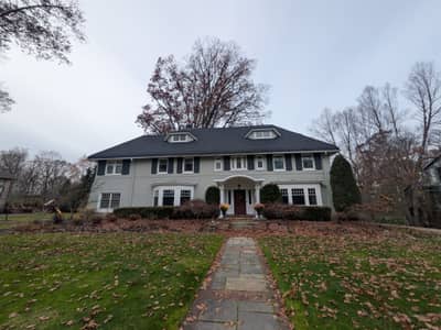 Large two-story colonial-style white house with centered entrance.