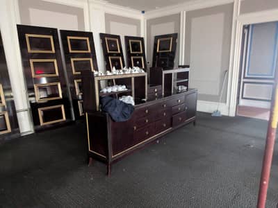 Commercial room with dark painted surfaces and gold-framed wall panels.