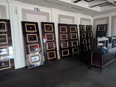 Commercial interior with walls featuring multiple gold-frame panel displays on dark background.