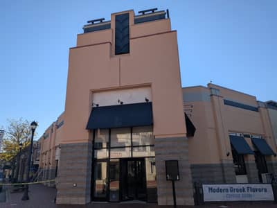 Commercial storefront with blue awnings and tan brick facade.
