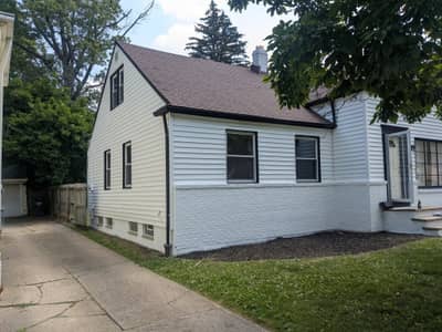 White house section showing upper facade with windows and gable.