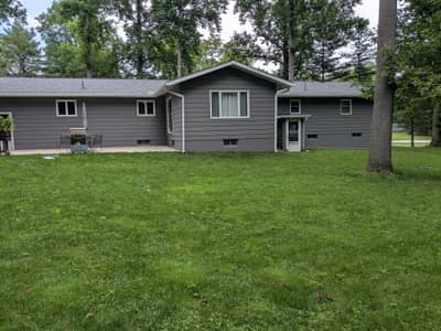 Single-story gray house with garage doors and landscaping.