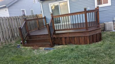 Wooden deck with brown-stained railing and balusters.