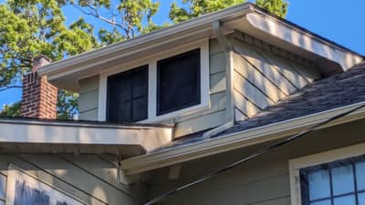 House roof section featuring brick chimney and slate-colored shingles.