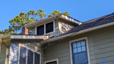 House roof area with brick chimney and architectural detailing.