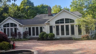 Two-story white colonial house with arched windows and attached garage.