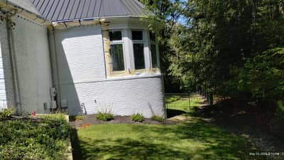 House exterior section showing white siding and standing-seam metal roof.
