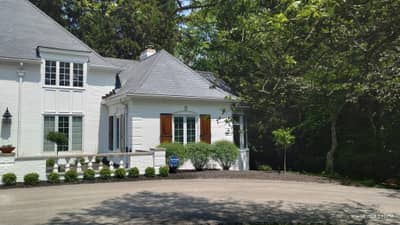 White house exterior showing front facade with garage and landscaping.