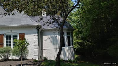 Cream-colored house exterior with attached garage and green landscape.