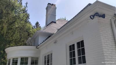 House roof section with white painted trim and brick chimney detail.