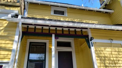 Yellow/cream colored house exterior with front windows.