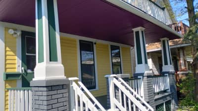 Porch area with purple/maroon awning and white support columns.