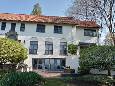 Exterior of a multi-story Mediterranean-style white house with terraces.