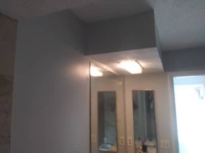 Interior room with ceiling-mounted lights and mirrored surfaces.