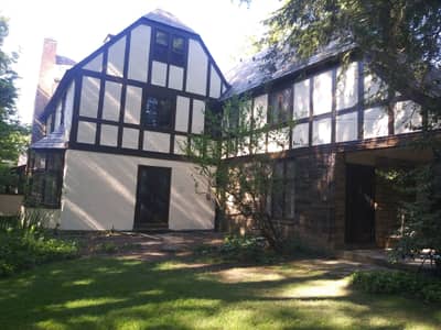 Black and white painted Tudor-style house exterior with decorative timber framing.