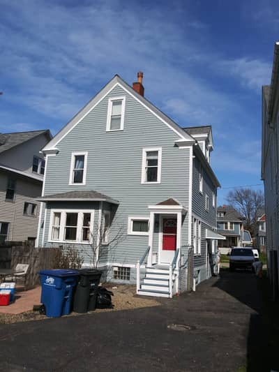 Light gray painted house with red front door and white trim.