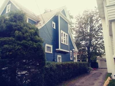 Multi-colored siding house with pale blue and darker blue painted sections.
