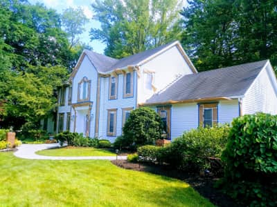 Pale blue and white painted house with dark roof and attached garage.