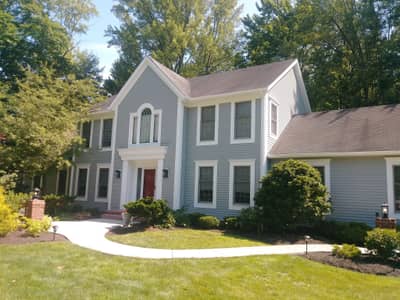 Pale green painted house with darker trim and attached structures.