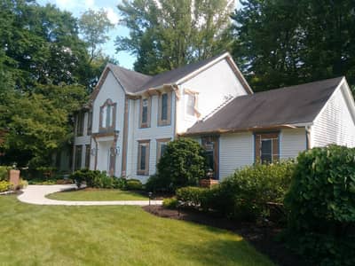 Light colored siding house with dark roof and multi-level design.