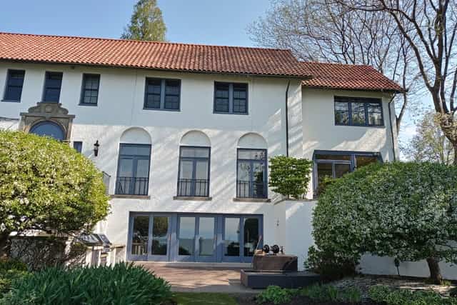 A white stucco elevation with arched windows and a red tile roof.